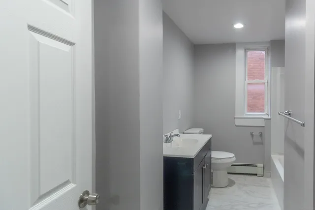 a bathroom with a toilet sink and mirror