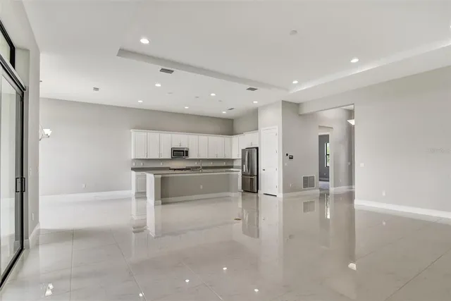 a kitchen with stainless steel appliances kitchen island granite countertop a refrigerator and a sink