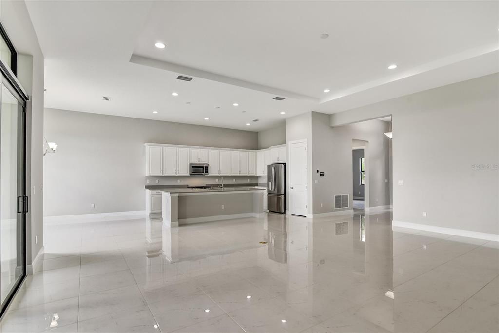 4533 Mondrian Court Sarasota, FL 34240 - Photo 15 of 49 a kitchen with stainless steel appliances kitchen island granite countertop a refrigerator and a sink