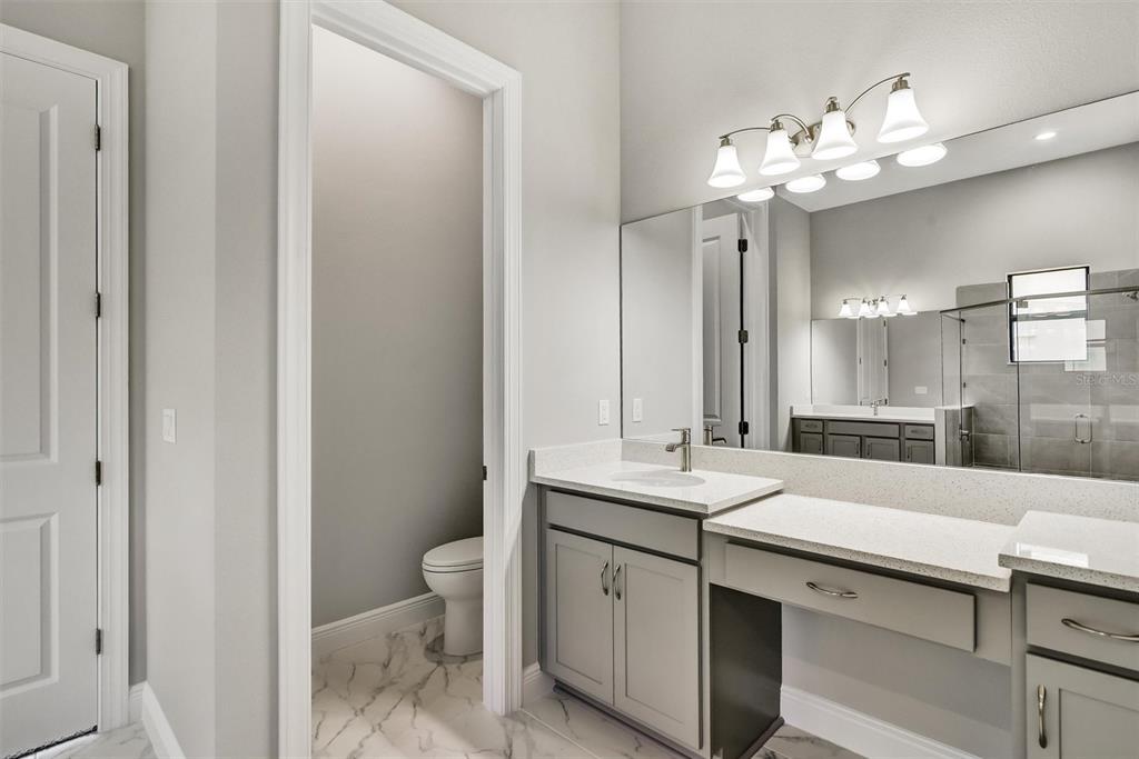 4533 Mondrian Court Sarasota, FL 34240 - Photo 23 of 49 a view of bathroom with a sink and mirror with toilet