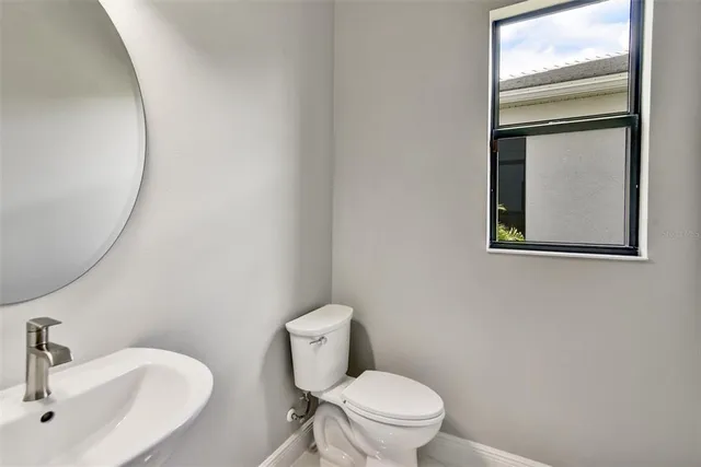 a white toilet sitting next to a bathroom sink