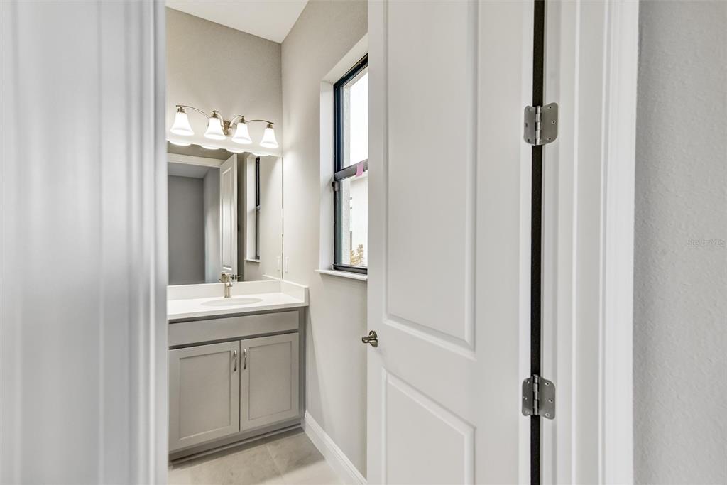 4533 Mondrian Court Sarasota, FL 34240 - Photo 38 of 49 a en suite bathroom with a sink mirror and vanity