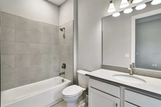 a bathroom with a granite countertop sink a toilet and bathtub