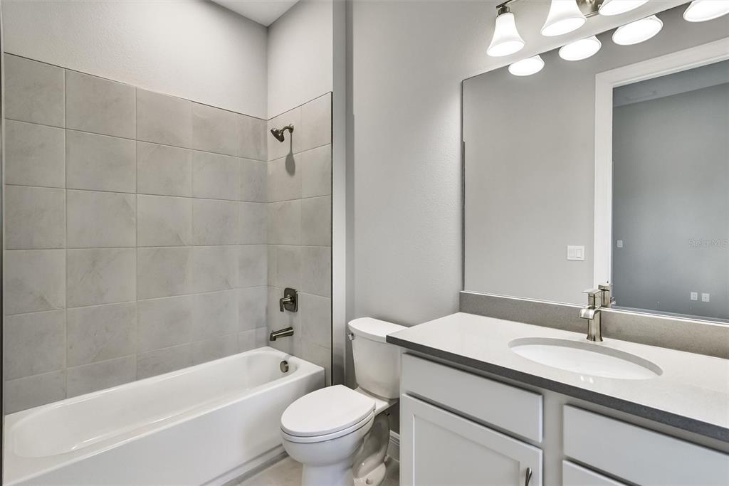 4533 Mondrian Court Sarasota, FL 34240 - Photo 39 of 49 a bathroom with a granite countertop sink a toilet and bathtub