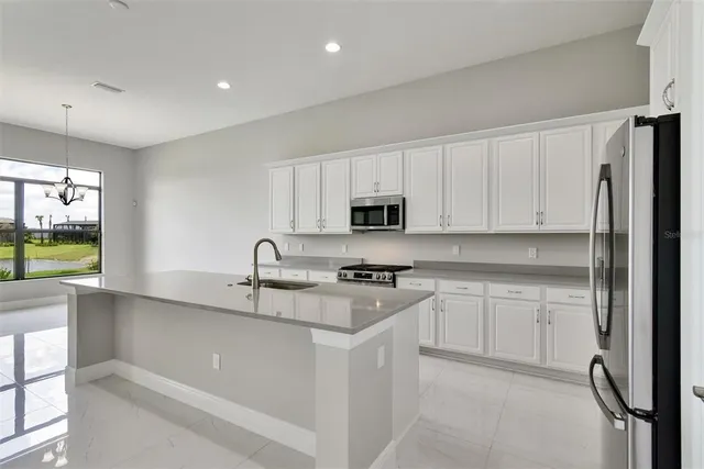 a kitchen with stainless steel appliances granite countertop a refrigerator and a stove top oven