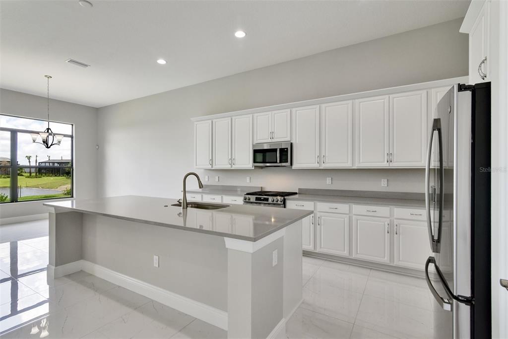 4533 Mondrian Court Sarasota, FL 34240 - Photo 9 of 49 a kitchen with stainless steel appliances granite countertop a refrigerator and a stove top oven