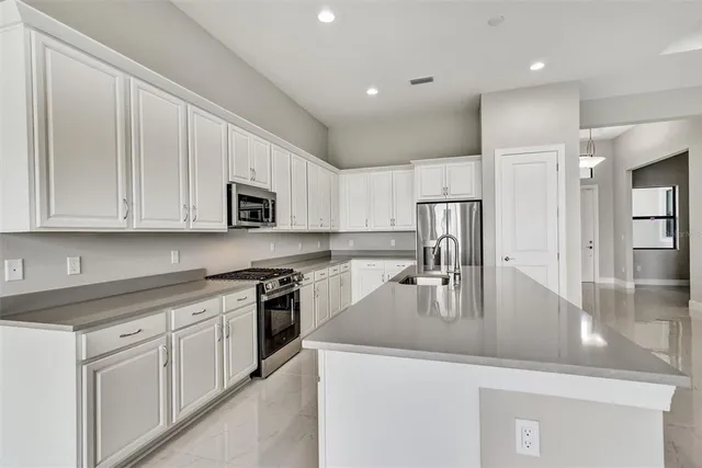 a kitchen with kitchen island granite countertop a sink a stove and refrigerator