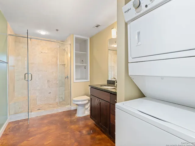 a bathroom with a granite countertop sink a toilet and shower