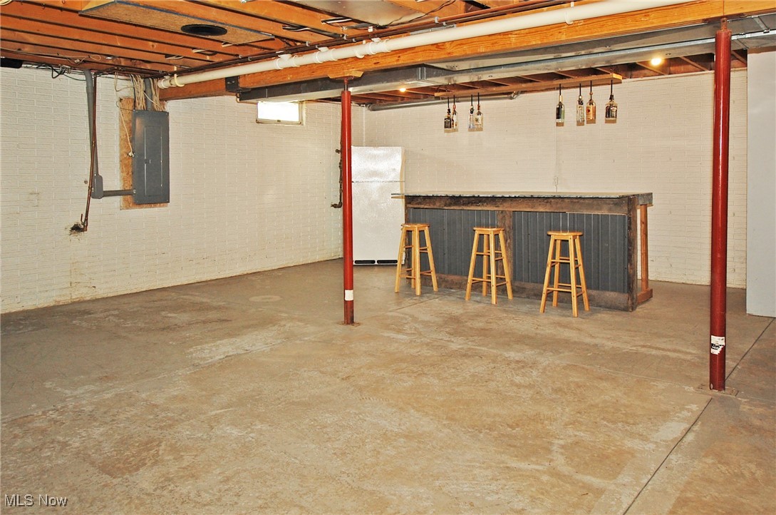 26875 W Road Wellington, OH 44090 - Photo 22 of 26 Basement with bar area, white fridge, and electric panel