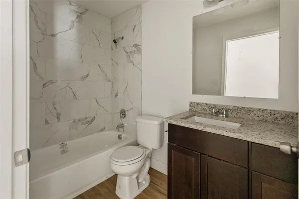 a bathroom with a granite countertop sink toilet and shower