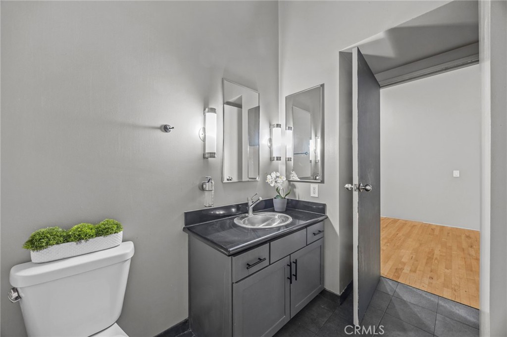 420 San Pedro Street, Unit 218 Los Angeles, CA 90013 - Photo 15 of 27 a bathroom with a granite countertop sink a toilet and shower