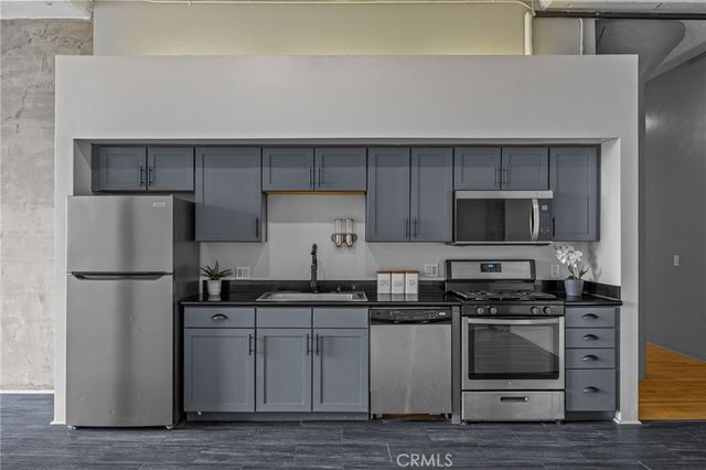 a large kitchen with stainless steel appliances wooden floors and wooden cabinets