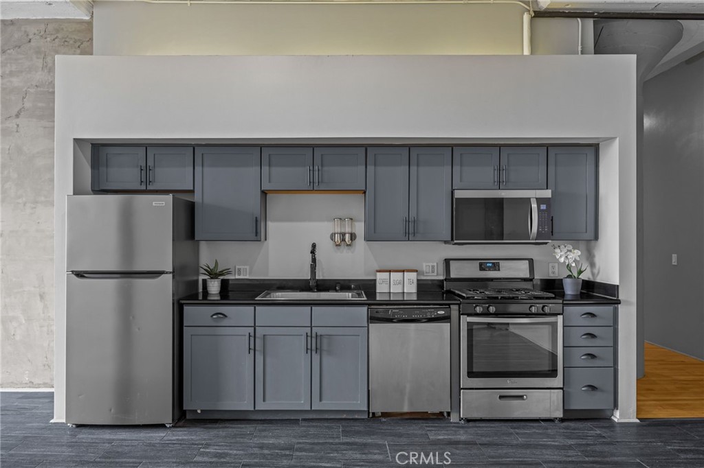 420 San Pedro Street, Unit 218 Los Angeles, CA 90013 - Photo 5 of 27 a kitchen with stainless steel appliances a refrigerator stove and microwave