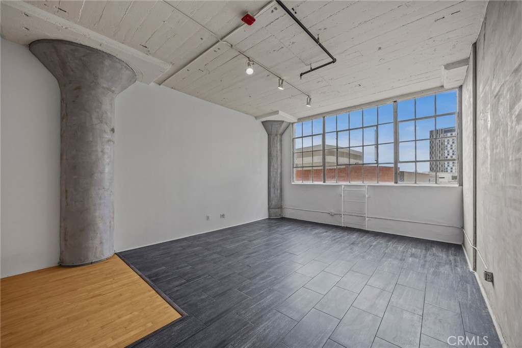 420 San Pedro Street, Unit 218 Los Angeles, CA 90013 - Photo 7 of 27 a view of an empty room with a window and wooden floor