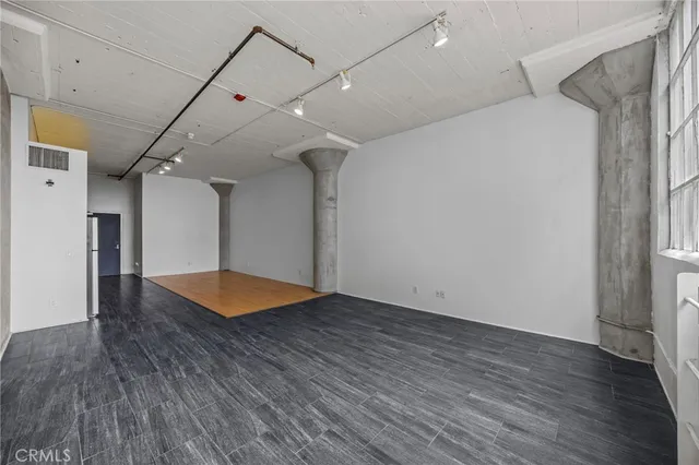 an empty room with wooden floor and fireplace