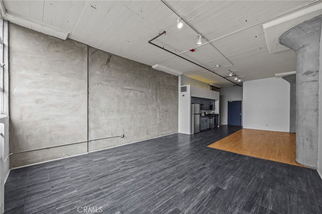 420 San Pedro Street, Unit 218 Los Angeles, CA 90013 - Photo 9 of 27 an empty room with wooden floor and fireplace