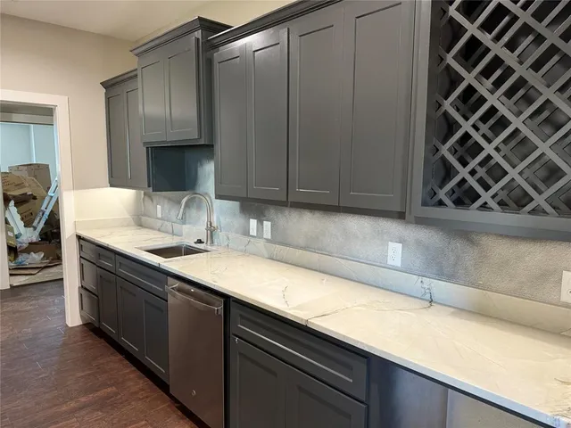 a kitchen with stainless steel appliances granite countertop a refrigerator a stove and a sink with wooden floor