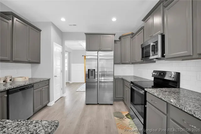 a kitchen with granite countertop stainless steel appliances and wooden cabinets