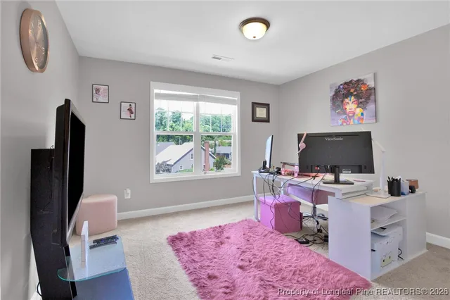 a view of a workspace with furniture and a window