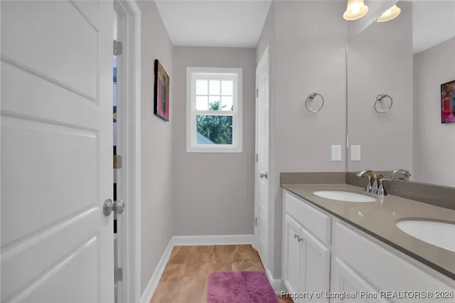 a bathroom with a granite countertop sink a mirror and shower