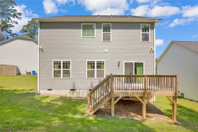 a view of a house with a deck and a yard