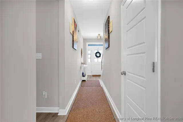 a view of a hallway with wooden floor and staircase