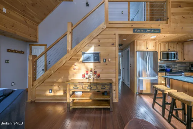 a kitchen with stainless steel appliances granite countertop a table chairs and a refrigerator