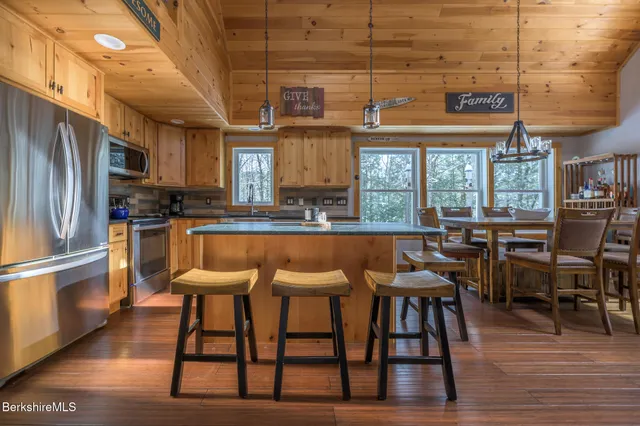 a kitchen with stainless steel appliances wooden floors wooden cabinets and sink