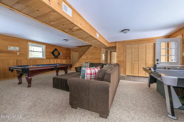 a living room with furniture pool table and a rug