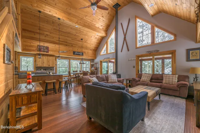 a living room with fireplace furniture and a large window