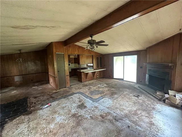 a view of an empty room and a kitchen