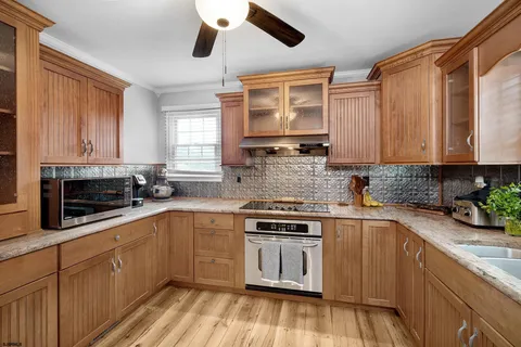a kitchen with stainless steel appliances a sink cabinets and wooden floor