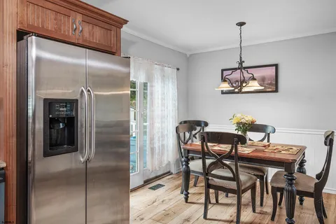 a view of a dining room with furniture a chandelier and wooden floor