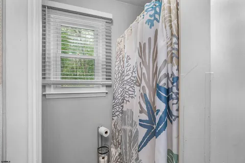 a bed sitting in a bedroom next to a window and a lamp