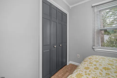 a living room with a dining table wooden floor and a chandelier