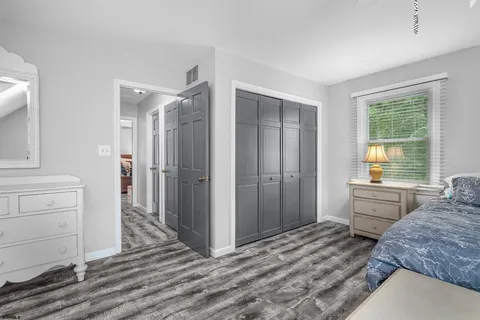 a view of a small house with a small yard and large trees