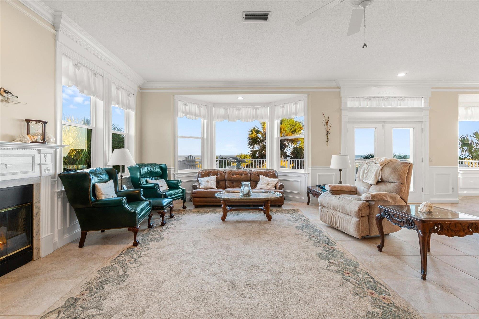 5042 Atlantic View St. Augustine, FL 32080 - Photo 13 of 72 Living area featuring a decorative wall, a wainscoted wall, ornamental molding, a fireplace, and plenty of natural light
