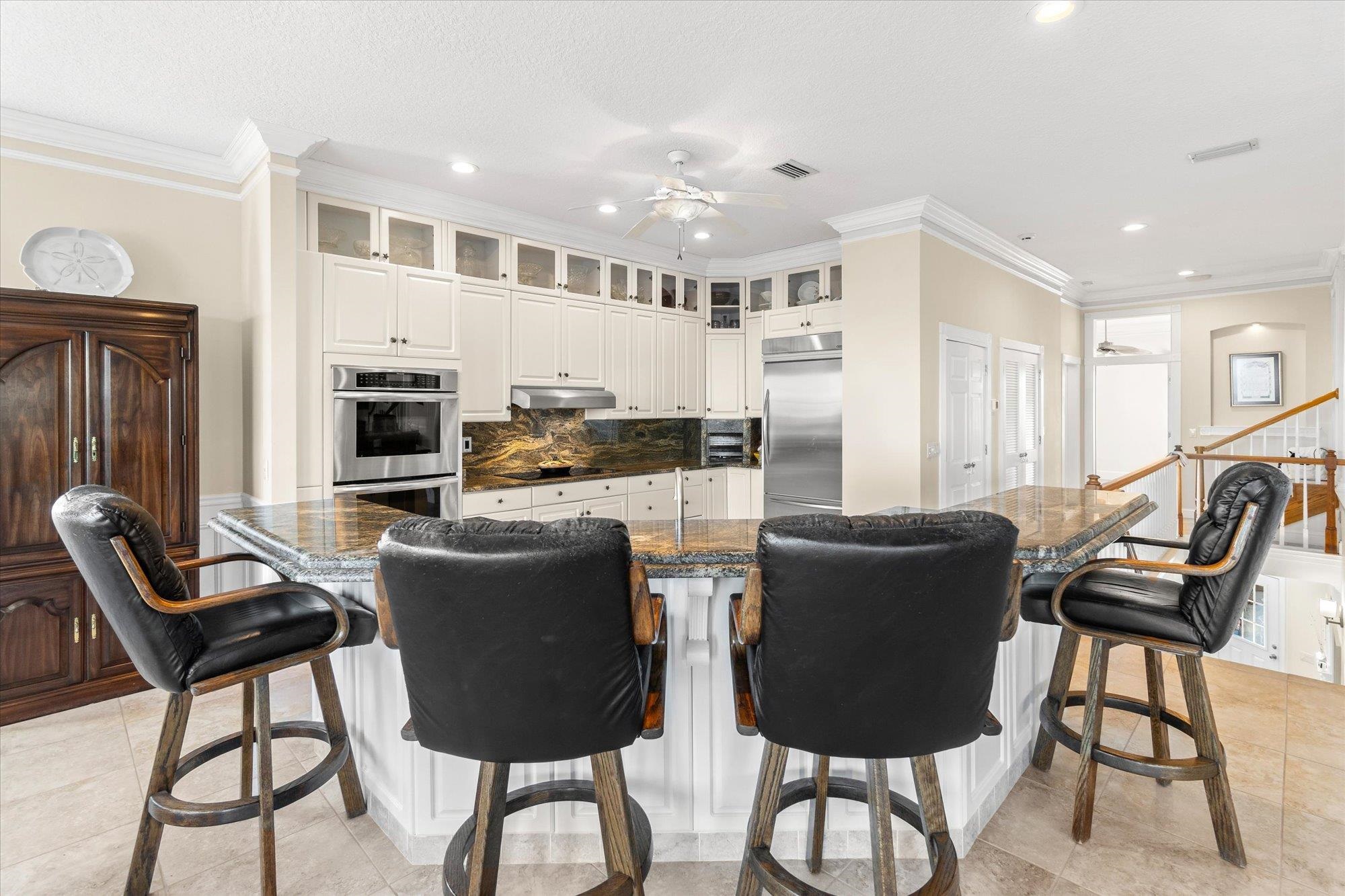 5042 Atlantic View St. Augustine, FL 32080 - Photo 15 of 72 Kitchen with a breakfast bar, stainless steel appliances, ornamental molding, white cabinetry, and backsplash