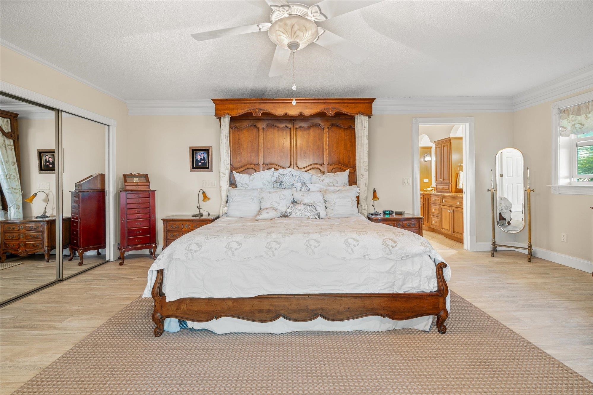 5042 Atlantic View St. Augustine, FL 32080 - Photo 19 of 72 Bedroom with a textured ceiling, a ceiling fan, light wood-type flooring, crown molding, and a closet