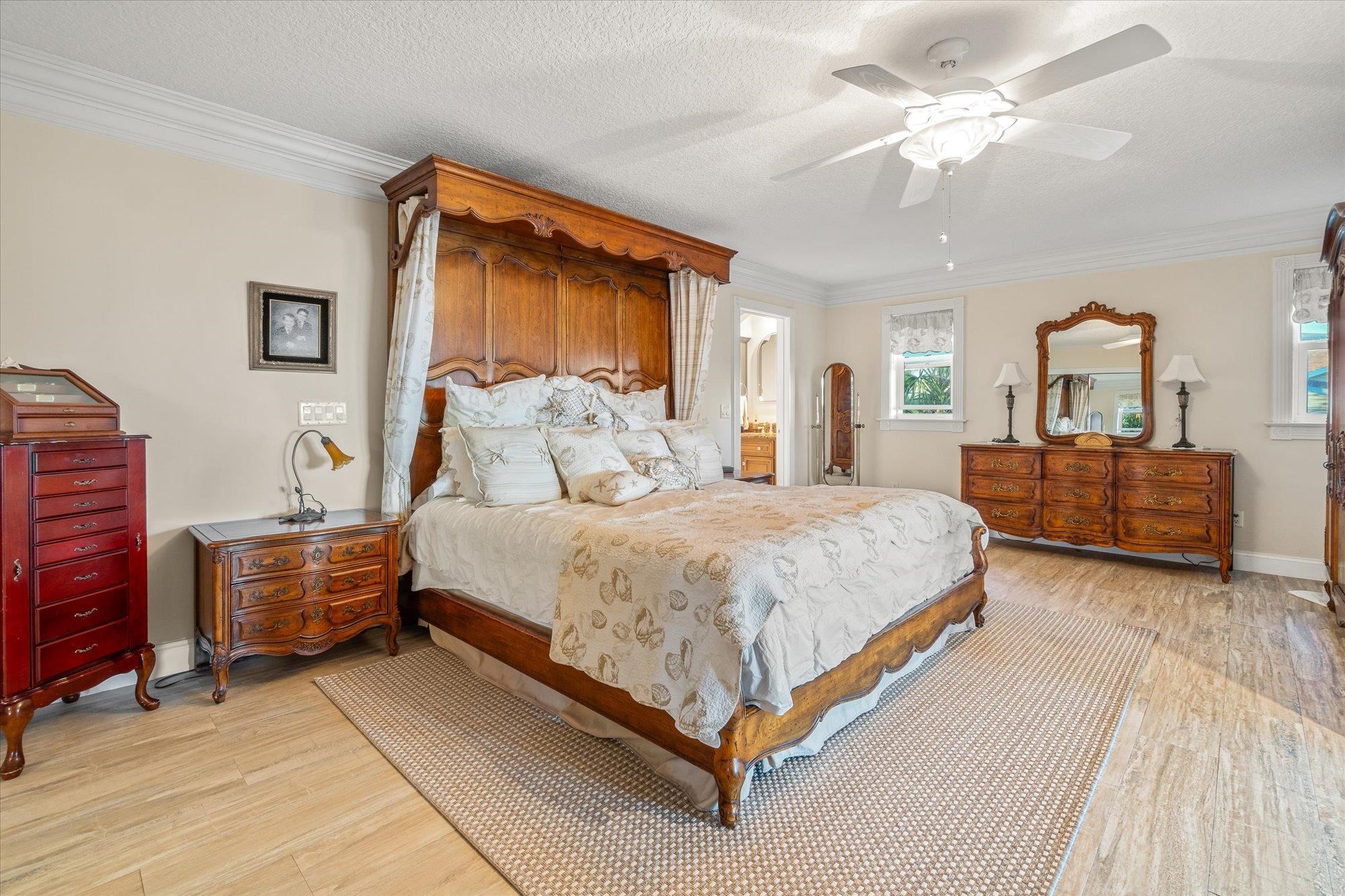 5042 Atlantic View St. Augustine, FL 32080 - Photo 20 of 72 Bedroom featuring crown molding, light wood finished floors, a textured ceiling, a ceiling fan, and connected bathroom