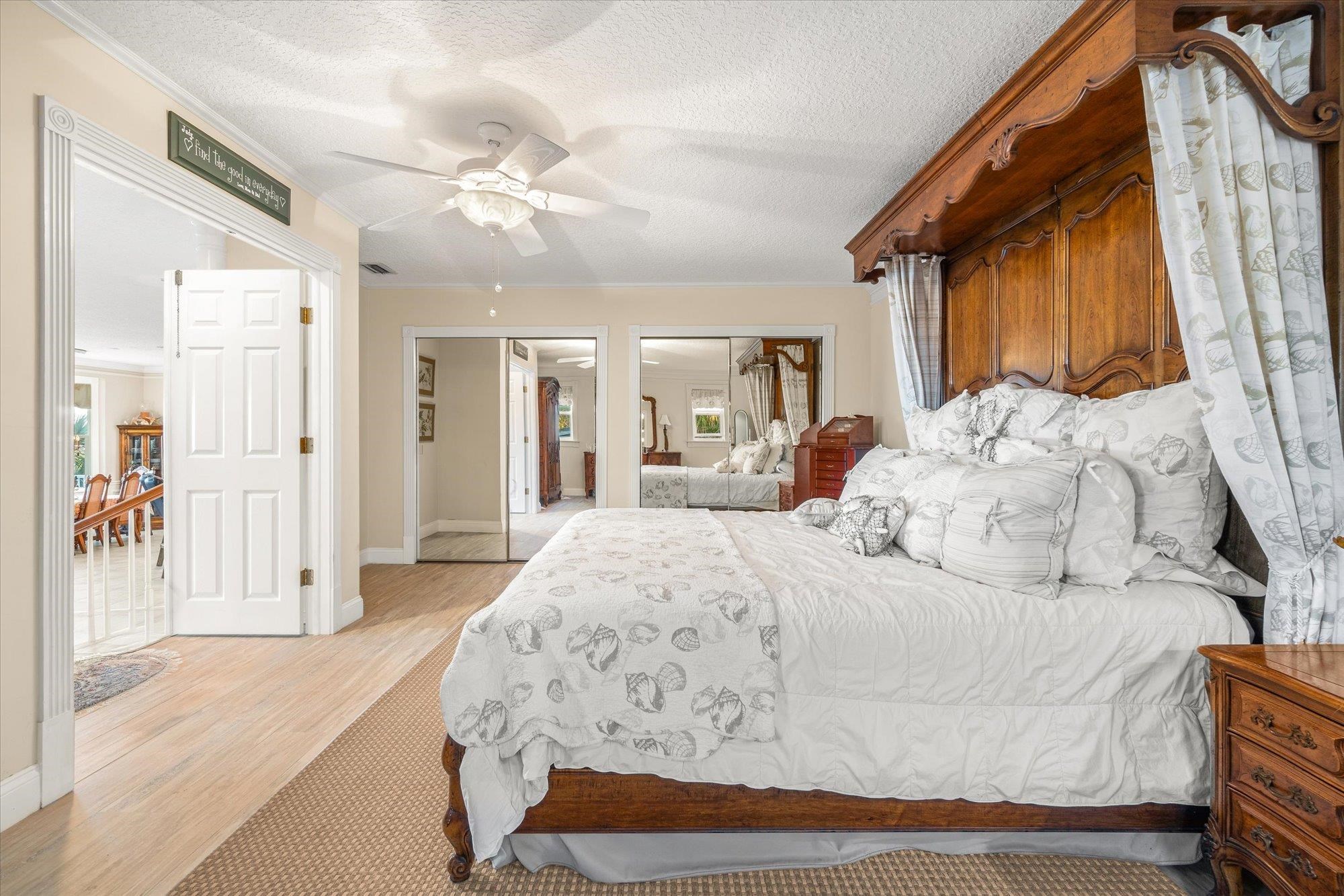5042 Atlantic View St. Augustine, FL 32080 - Photo 21 of 72 Bedroom featuring two closets, light wood-style flooring, a textured ceiling, ceiling fan, and crown molding