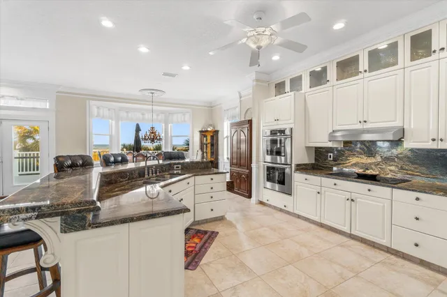 a kitchen with granite countertop a refrigerator oven and white cabinets