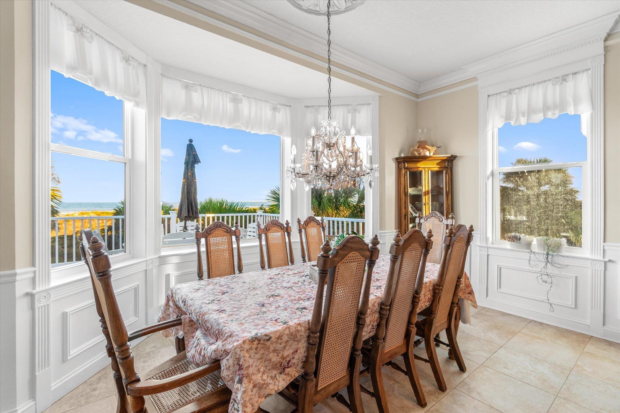 5042 Atlantic View St. Augustine, FL 32080 - Photo 9 of 72 Dining space featuring a decorative wall, wainscoting, ornamental molding, a chandelier, and light tile patterned floors