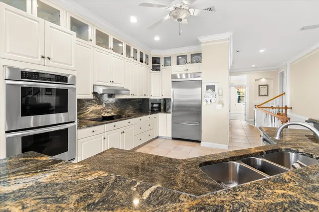 a kitchen with granite countertop white cabinets and stainless steel appliances