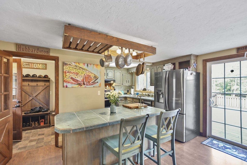 28 Adams Road Hubbardston, MA 01452 - Photo 10 of 35 a kitchen with stainless steel appliances kitchen island granite countertop a table and chairs in it