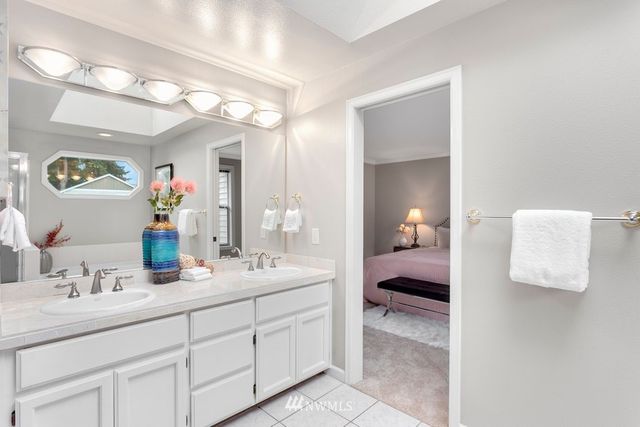 a en suite bathroom with a double vanity sink and a mirror