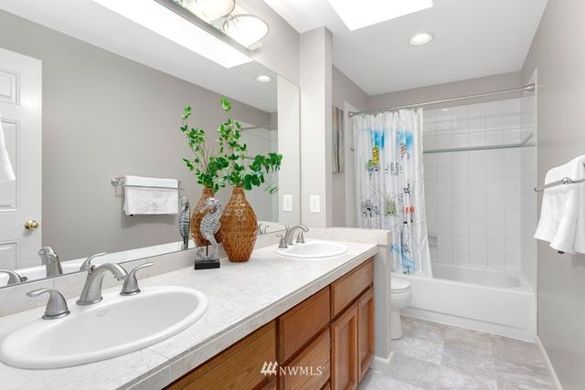 a bathroom with a double vanity sink a large mirror and shower