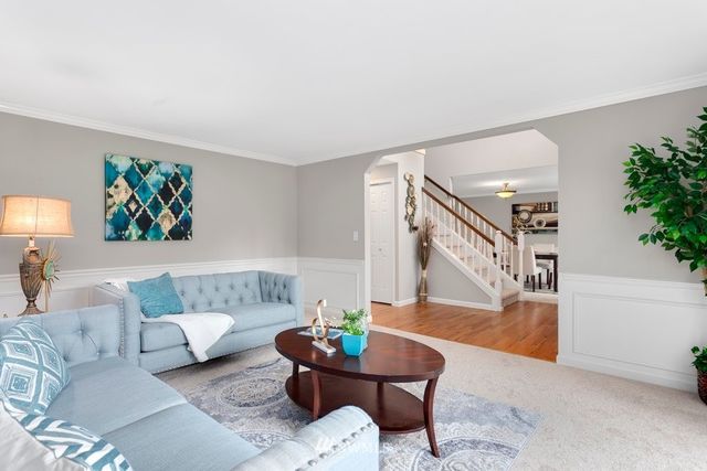 a living room with furniture and a painting on the wall