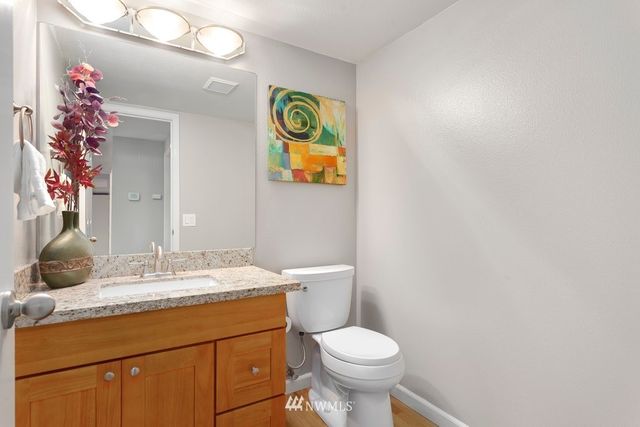 a bathroom with a granite countertop sink and a mirror