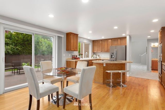 a dining room with furniture a large window and a kitchen view